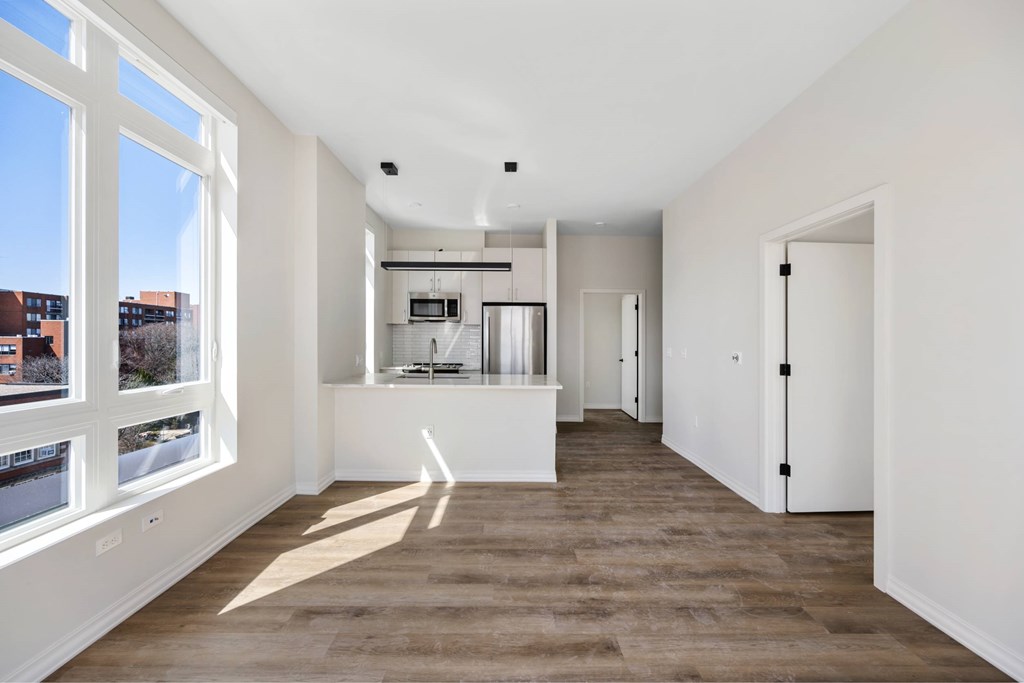 a living room with a large window and a kitchen
