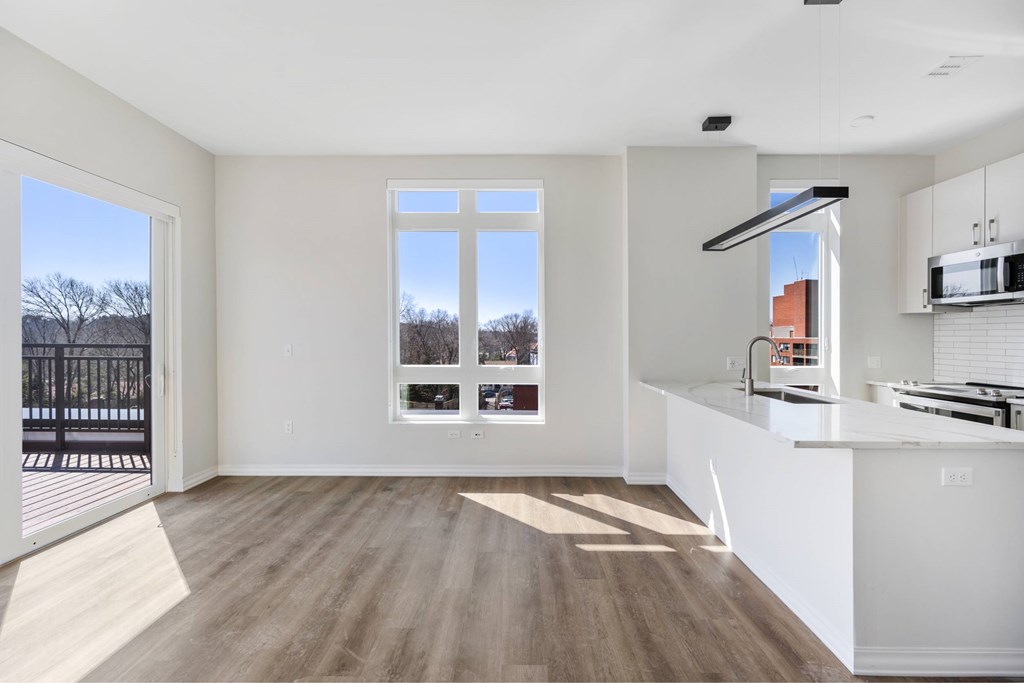 a white kitchen with a large window and a counter