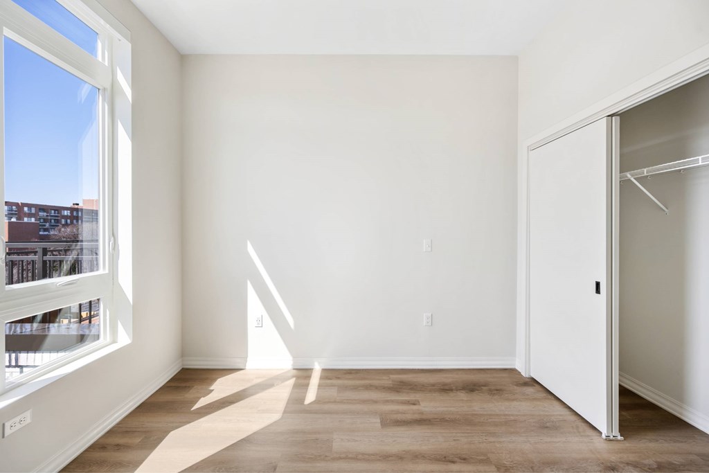 a living room with white walls and a large window