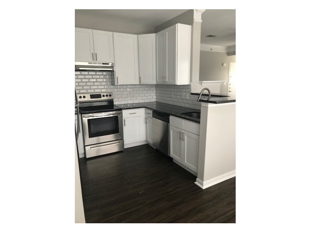 a kitchen with white cabinets and a stove top oven