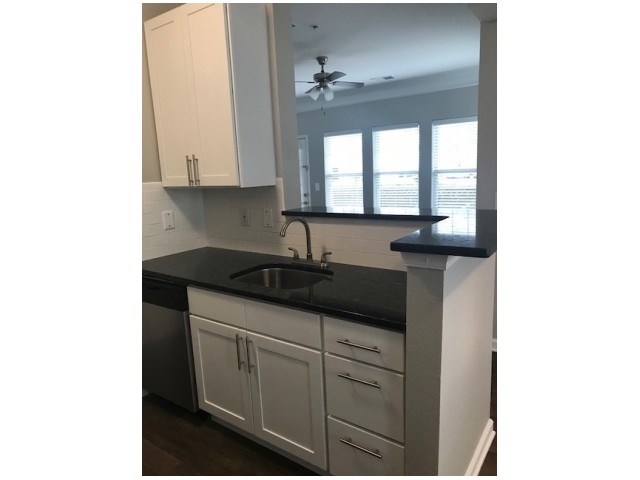 a kitchen with white cabinets and a sink and a window