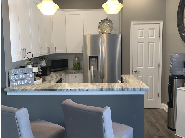 a kitchen with a granite counter top and a stainless steel refrigerator