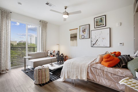 a bedroom with a bed and a couch and a window