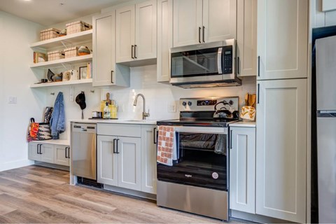 A kitchen with a stove top oven and a microwave above it.