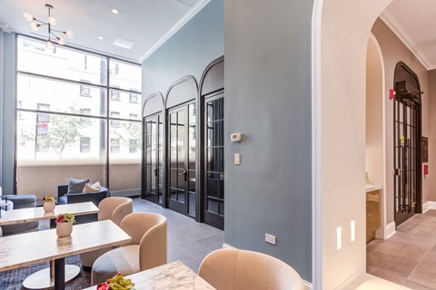 a dining area with tables and chairs and a lobby with glass doors