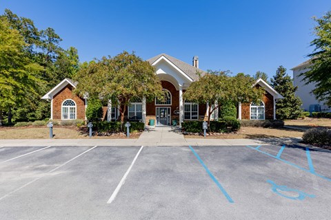 the front of a house with a parking lot and trees