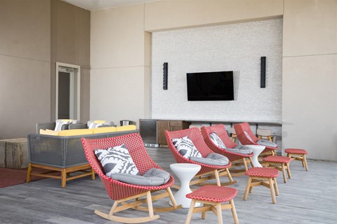 A living room with a grey sofa and red chairs.