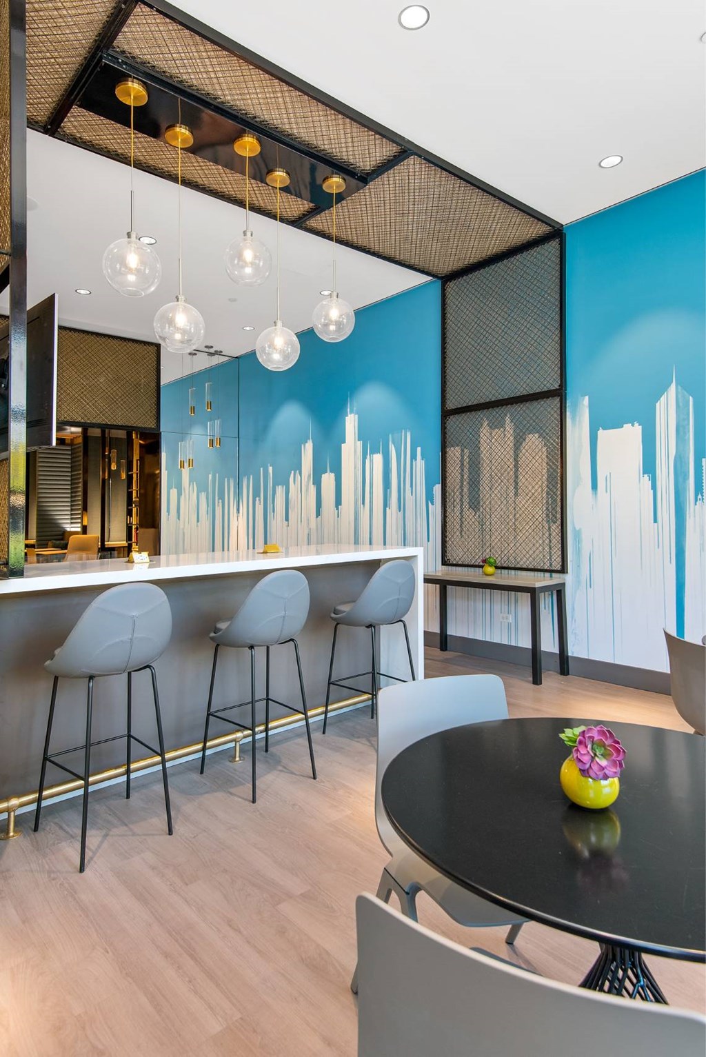 a dining room with a table and chairs and a blue wall with a skyline painted