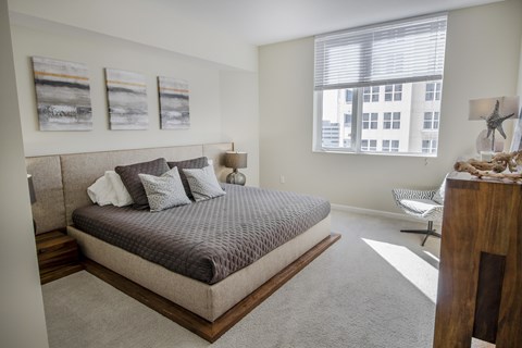 a bedroom with a bed and a large window