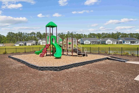 our playground has a variety of play equipment with houses in the background