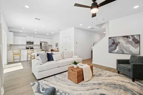 A modern living room with a white sofa and a ceiling fan.