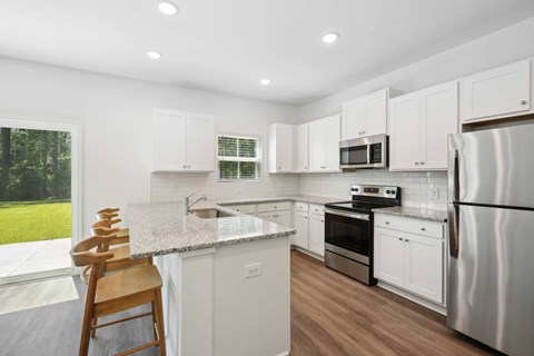 A kitchen with white cabinets and stainless steel appliances.