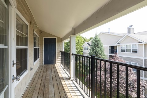 a covered porch with a door to a house