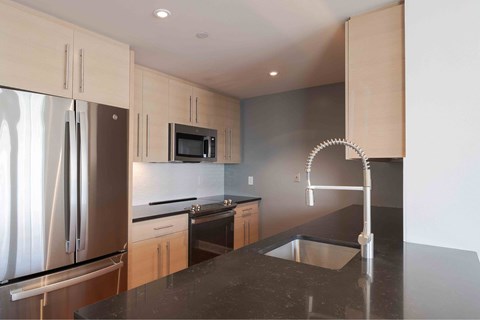 a kitchen with black counter tops and stainless steel appliances