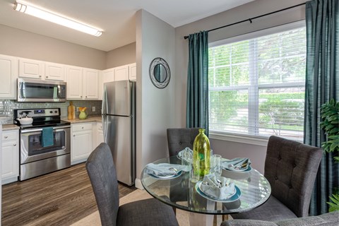 a kitchen and dining room with stainless steel appliances and a glass table