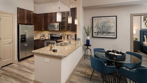 A kitchen with a table and chairs in front of it.