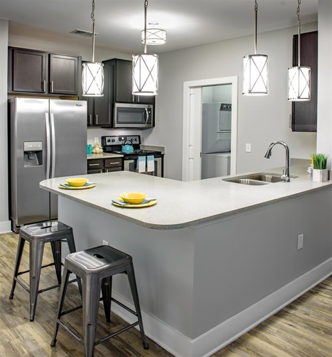 A kitchen with a white counter top and a refrigerator.