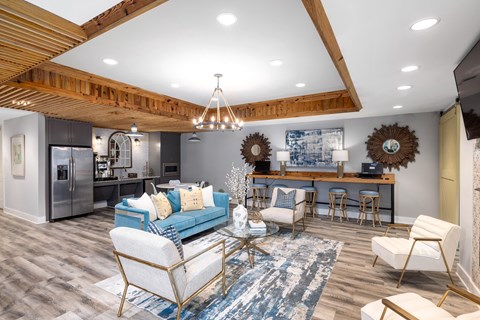 A modern living room with a blue sofa and a wooden ceiling.