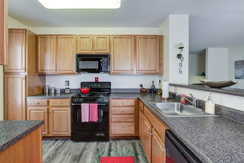 a kitchen with granite counter tops and wooden cabinets