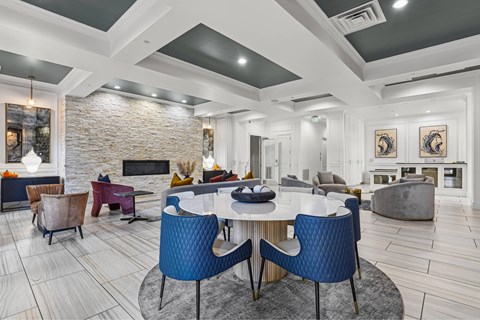 A modern dining room with a stone fireplace and a large table surrounded by chairs.