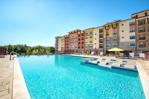 A large swimming pool in front of apartment buildings.