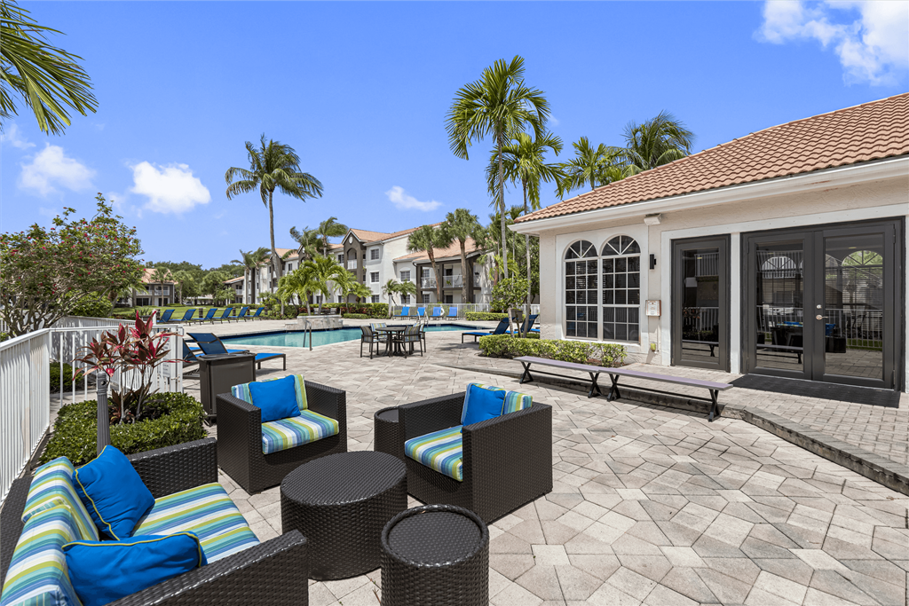 a patio with chairs and tables and a swimming pool