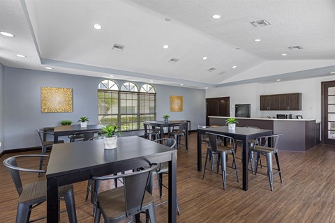 a dining room with tables and chairs and a kitchen