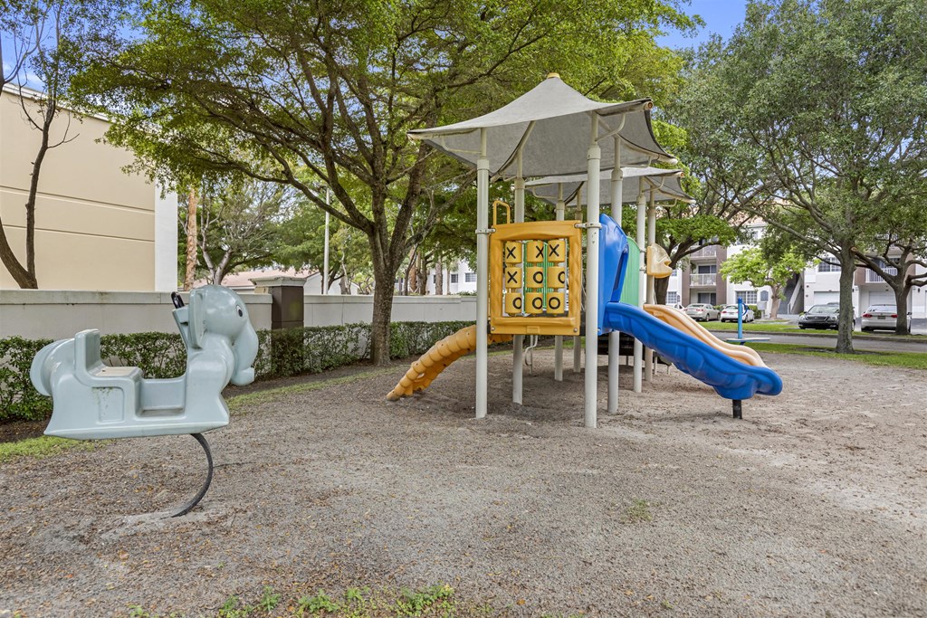 a playground with a swing and slides in a park