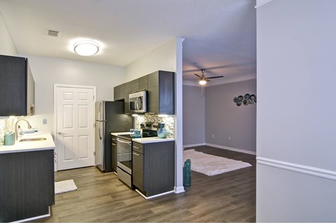 an open kitchen and living room with a stainless steel refrigerator and stove