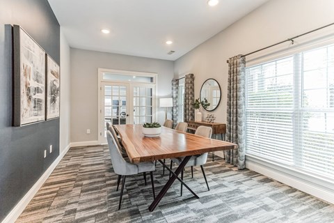 A dining room with a wooden table and chairs.