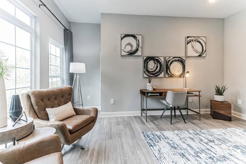 A modern living room with a brown chair and a grey couch.