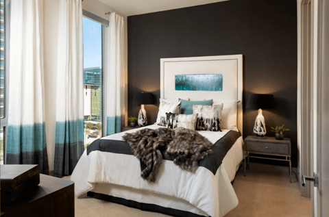 A bedroom with a large bed and a view of the outside.