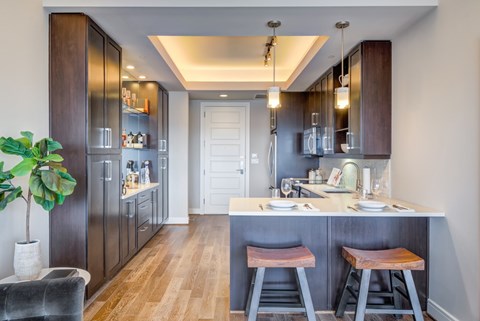 A kitchen with dark wood cabinets and a white island.