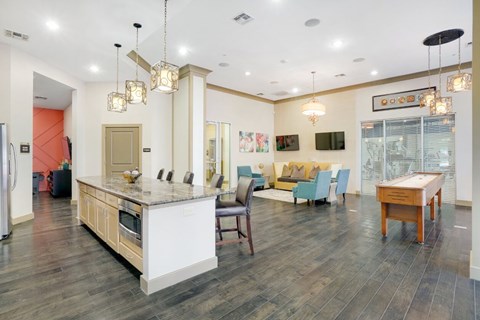 A kitchen with a white island and a dining table with chairs.