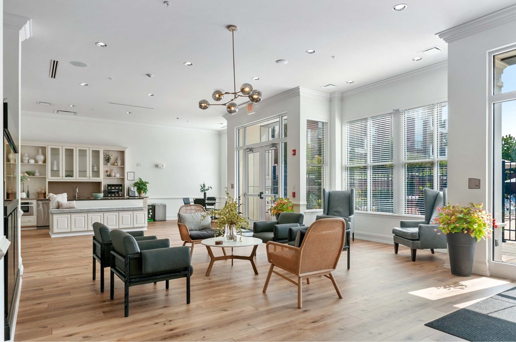 A modern living room with a kitchen in the background.