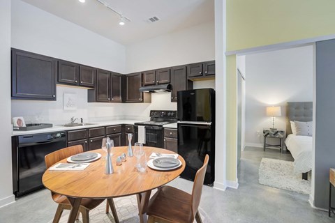 A modern kitchen with a dining table set for two.