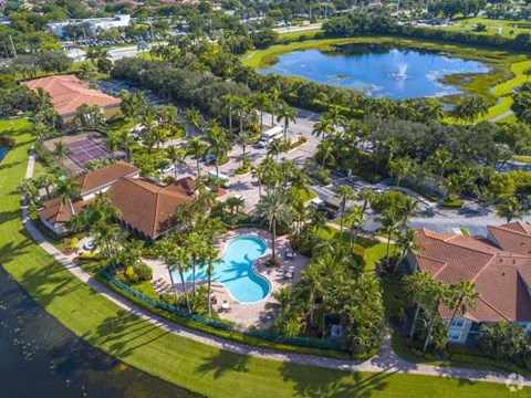 A beautiful aerial view of a resort with a swimming pool and palm trees.