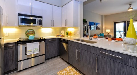 A kitchen with dark wood cabinets and a stainless steel dishwasher.
