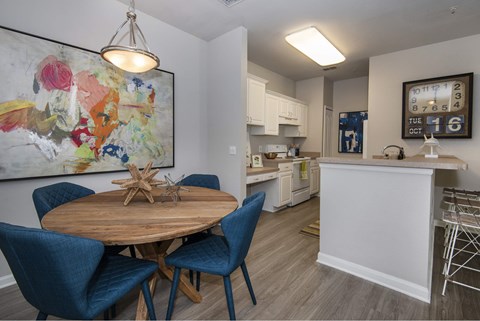 A kitchen with a dining table and chairs.