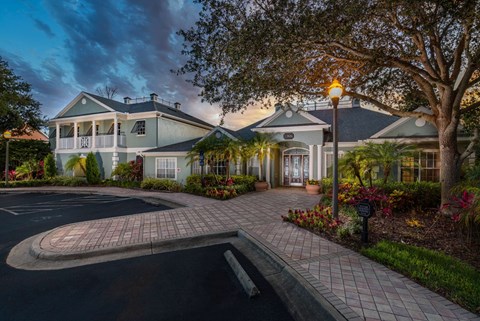 A large house with a driveway and a tree in front.