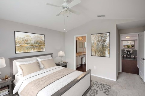 A bedroom with a large bed and a ceiling fan.