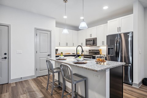 A kitchen with a table and chairs and a fridge.