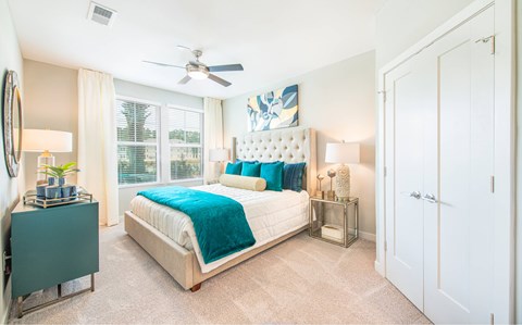 A bedroom with a large bed and a ceiling fan.