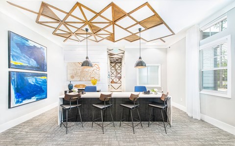 A modern kitchen with a large island and a dining table with chairs.