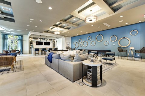 A modern living room with a large sectional sofa and a TV in the background.