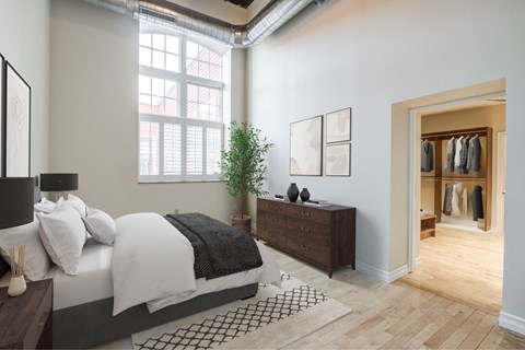 A bedroom with a large bed and a wooden dresser.