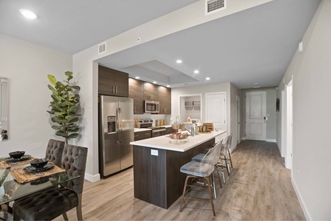 A modern kitchen with a glass dining table and chairs.