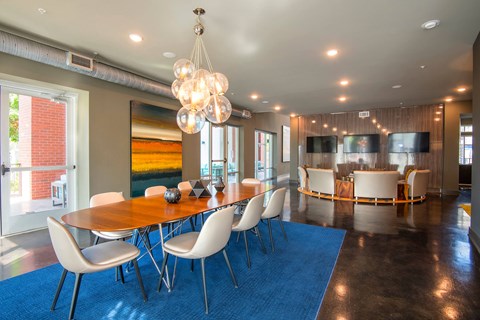 A dining room with a wooden table and white chairs.