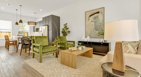 A living room with a green chair and a wooden coffee table.
