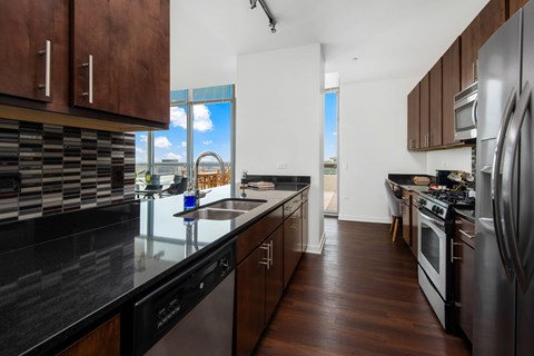 A modern kitchen with dark wood cabinets and stainless steel appliances.